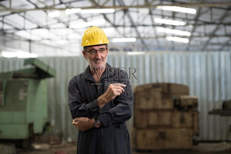 工厂内一位年长男性工程师的肖像年长男性技术员穿着安全制服佩戴安全